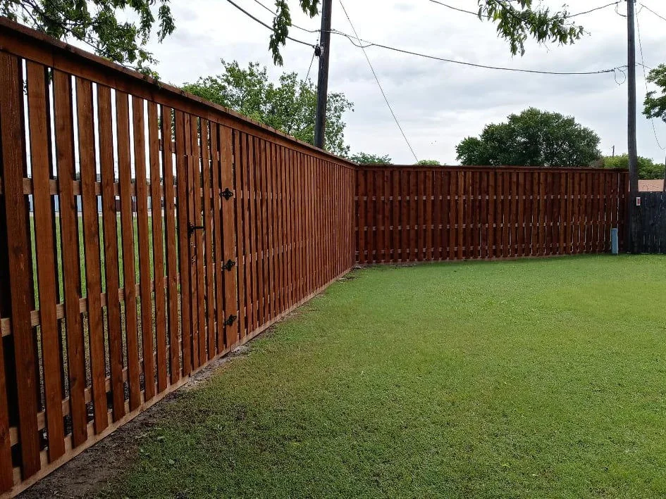 Wood fence enclosing a green yard